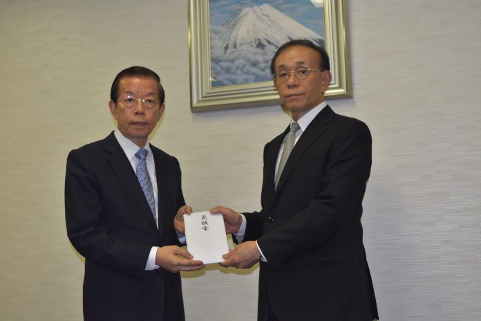 謝長廷代表(左)は谷崎泰明理事長に寄付目録を手渡した