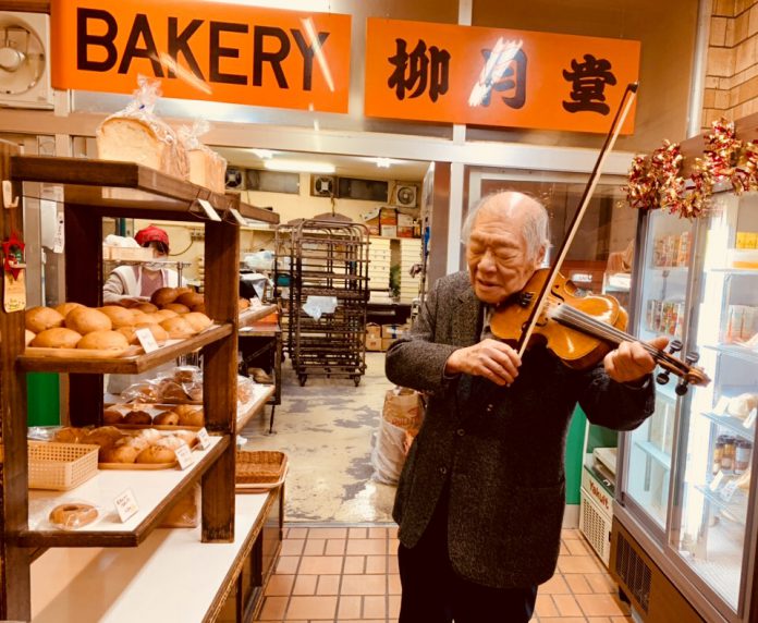 在麵包屋中拉小提琴的陳芳福