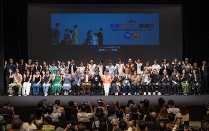 21屆大阪亞洲影展開幕，翁倩玉女士(中間橘色上衣者)、褚明仁董事長(中間戴帽者)和影展上映作品之電影人士合影。(照片由大阪亞洲影展提供)