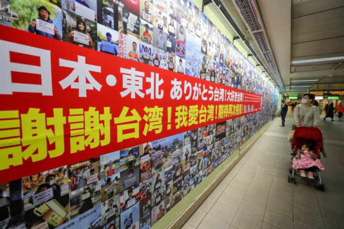 2021年311地震10週年前夕,日本民間發起用照片向台灣說愛活動,超過1200名當年受災的東北地區民眾,以影像寫下他們對台灣的謝意與感情,逾千張照片組成的照片牆豎立在台北捷運中山站入口,見證台日友誼。(圖:中央社) 2021年311地震10週年前夕,日本民間發起用照片向台灣說愛活動,超過1200名當年受災的東北地區民眾,以影像寫下他們對台灣的謝意與感情,逾千張照片組成的照片牆豎立在台北捷運中山站入口,見證台日友誼。(圖:中央社)